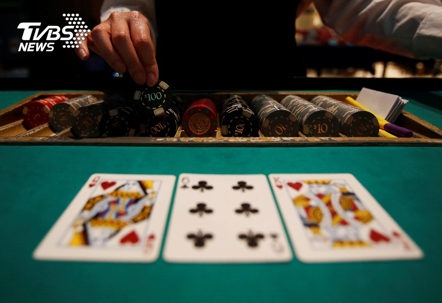 A dealer picks up chips on a mock black jack casino table during a photo opportunity at an international tourism promotion symposium in Tokyo